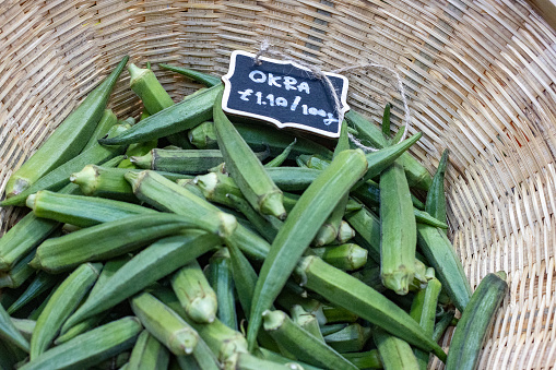 Fresh fava beans, peeled and in pods on a wooden table.