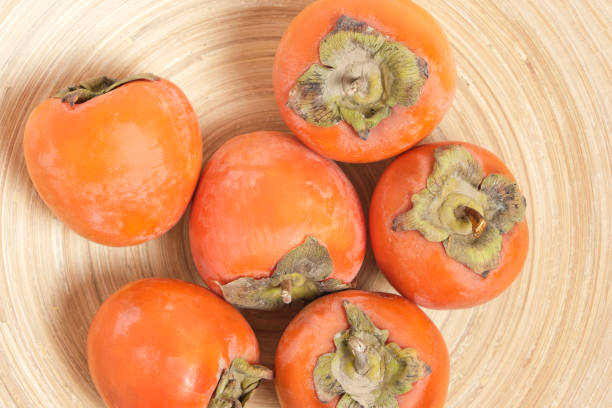 istock Fruits of persimmon fruit in plate, top view. 1367778561