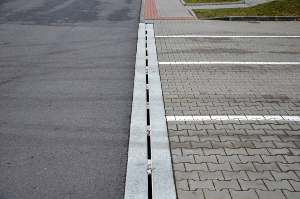 drainage element in interlocking paving concrete gutter with slotted drain from one piece of concrete can hold water from the parking lot along the entire length of the yard