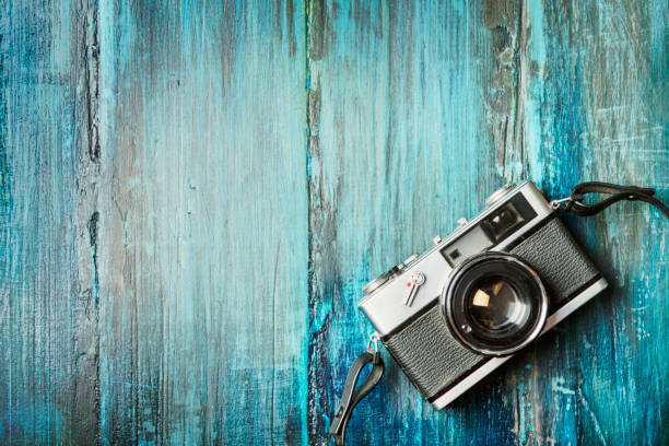 Vintage photo camera on grunge wooden background Vintage photo camera on grunge blue wooden background with copyspace. old black leather photo album stock pictures, royalty-free photos & images