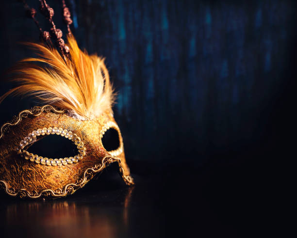 Venetian mask Golden venetian ball mask over dark background with copyspace. Masquerade party or holiday event celebration concept. fancy dress costume stock pictures, royalty-free photos & images