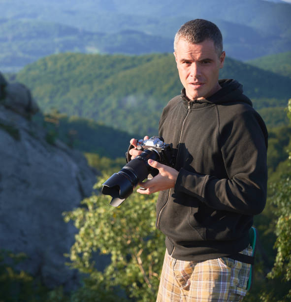 istock Photographer with digital camera on top of mountain 1367787606
