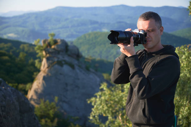 istock Photographer with digital camera on top of mountain 1367787609