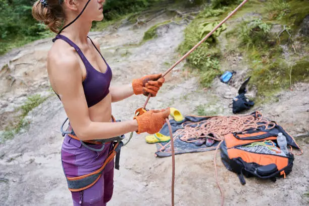 Photo of Female climber belaying the leader during a rock climbing
