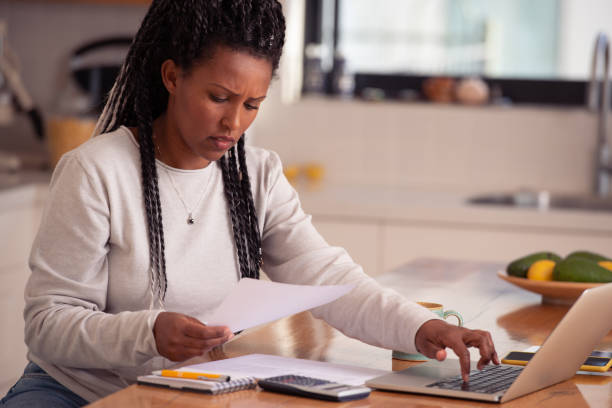 istock A freelance woman working from home in the kitchen, using a laptop, reading documents. 1367788813