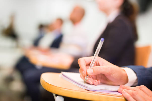 istock Hand of businessman writing notes at conference 1367789008