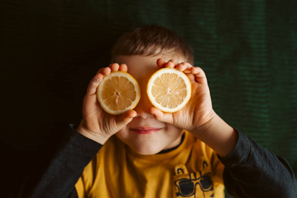 istock Healthy smiling boy with lemon 1367789267