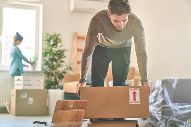 istock Caucasian couple carrying paper boxes while moving house 1367794688