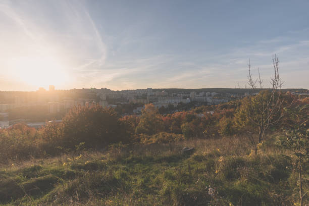 beautiful colors of autumnal sunset over block of flats with bushes and trees around