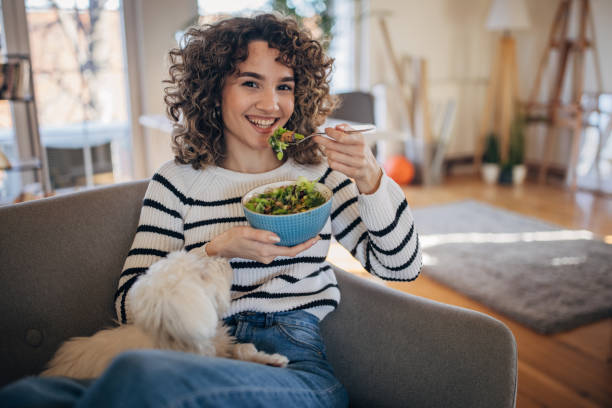 istock Young woman eating a salad 1367799267