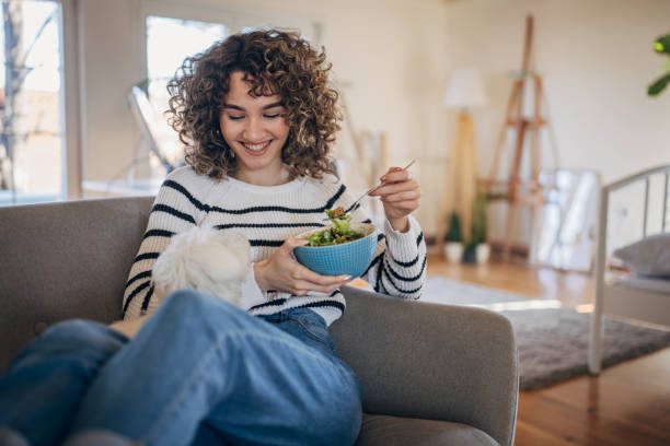 istock Young woman eating a salad 1367799795
