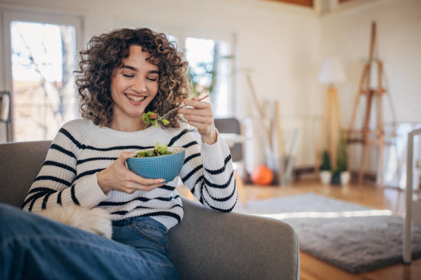 istock Young woman eating a salad 1367799806