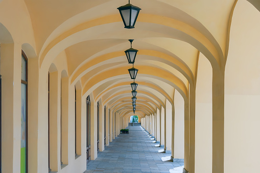 Arched colonnade with hanging lanterns. Perspective. Summer. Day.