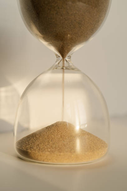 istock Transparent hourglass on a white sunny background. 1367800377