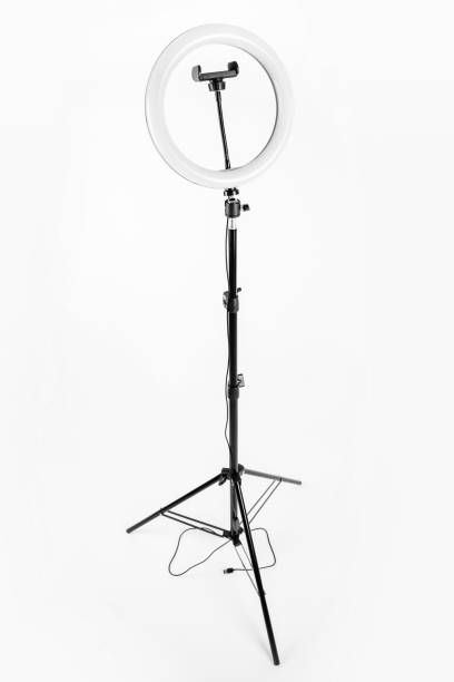 istock LED ring lamp on a high tripod. White background. 1367801545