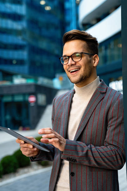 istock Successful happy business man working on digital tablet in urban background 1367801773