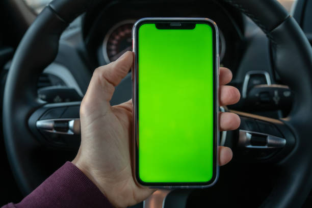 pessoa dentro de seu carro olhando para o celular e usando o gps móvel - driving mobile phone car talking - fotografias e filmes do acervo