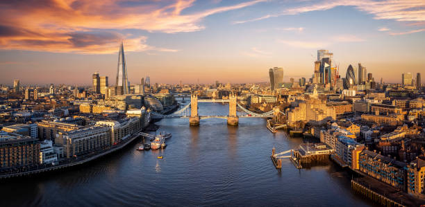 panoramic sunrise view of the skyline of london - tower bridge stockfoto's en -beelden