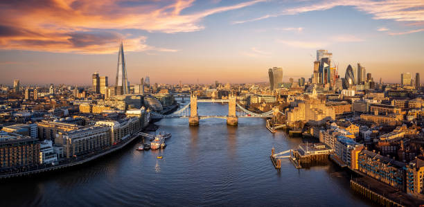 Panoramic sunrise view of the skyline of London Panoramic sunrise view of the skyline of London with Tower Bridge and the skyscrapers of the city in golden sunlight city of london stock pictures, royalty-free photos & images