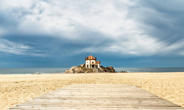 chapel in the middle of the beach next to the water of Senhor da Pedra in Miramar, Portugal. chapel in the middle of the beach next to the water of Senhor da Pedra in Miramar, Portugal vila nova de gaia stock pictures, royalty-free photos & images