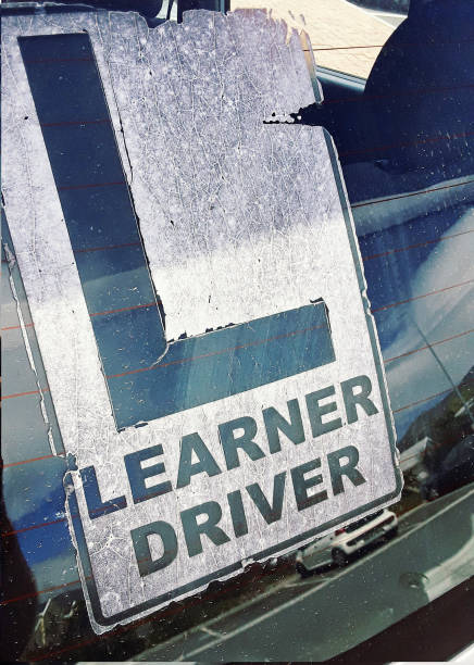Very old, weathered L-plate on a car's rear window, denoting a learner driver