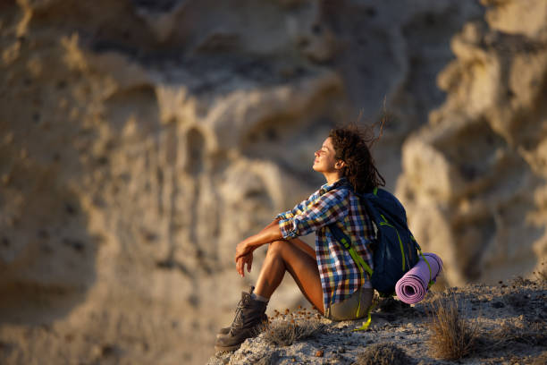 istock Smiling female hiker taking a break on a rock formation. 1367803701