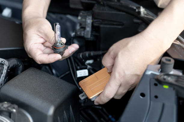 istock A man hold Xenon car headlights and Ballast inserted into the headlight to replace the broken bulb in engine room : Replacing the headlight bulbs of the car itself service concept 1367805185