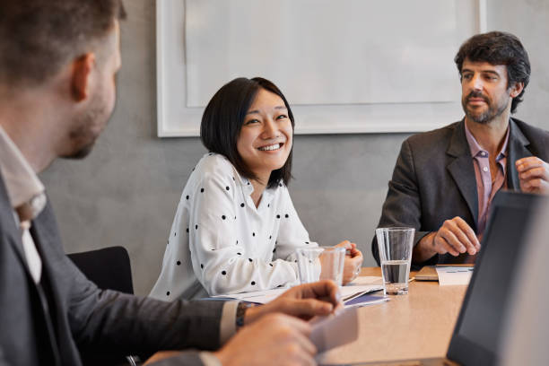 istock Smiling entrepreneur with colleagues in board room 1367805895