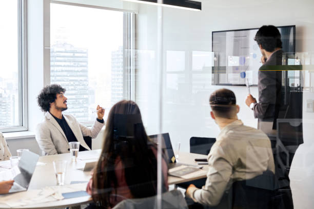istock Manager presenting to coworkers in board meeting 1367805963