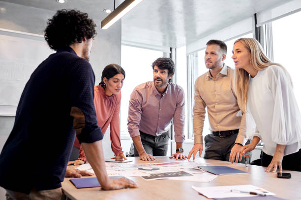 istock Manager and coworkers standing in conference room 1367806135
