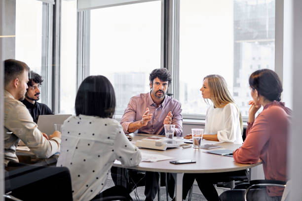istock Manager discussing with colleagues in board room 1367806136
