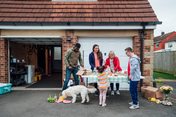 Community Easter Yard Sale Family having an Easter yard sale in their garden in the North East of England. They have handmade easter crafts on a table and chocolate snacks. One of the sellers has down syndrome. Some products are on the floor and the family dog is also with them. dog disruptagingcollection stock pictures, royalty-free photos & images