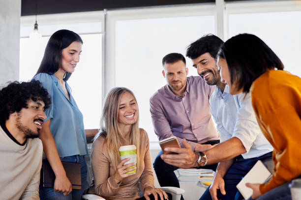 istock Manager showing smart phone to coworkers in office 1367806481