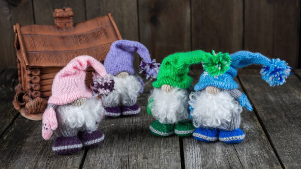 Bright handmade knitted toys, gnomes in a hat on a rustic wooden table stock photo