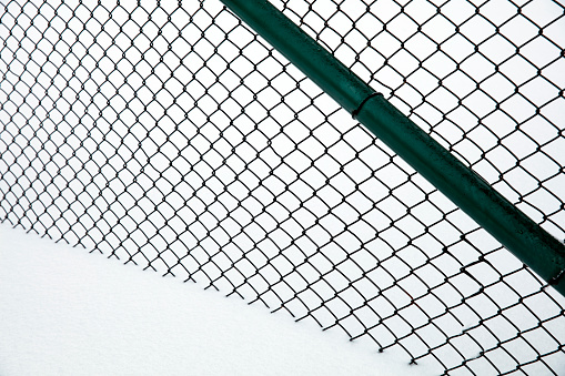 Wire mesh fence covered with snow