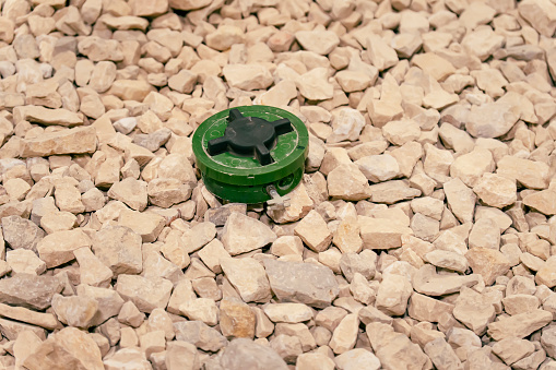 A green anti-personnel mine on the rocks. Mine clearance