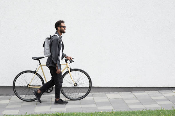 istock Handsome young man with bicycle in a city 1367809052