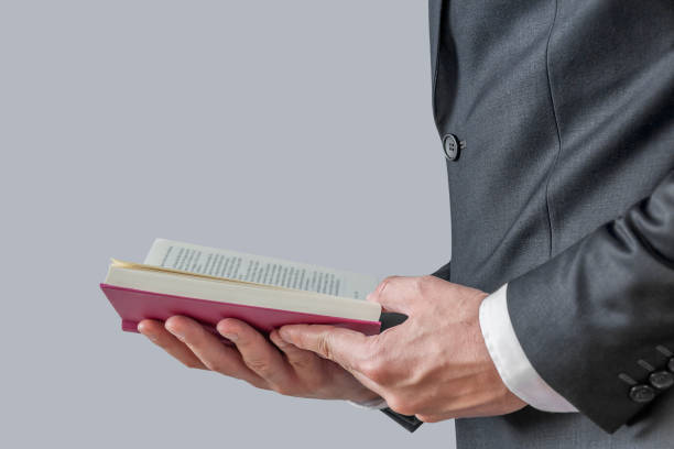 istock Businessman in a suit holding a open book 1367809089