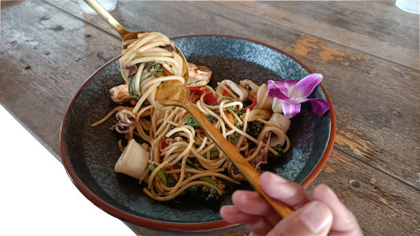 istock Use a spoon and fork to roll hot spicy spaghetti with seafood 1367811788