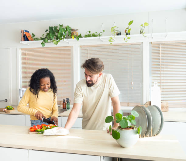 istock Young multi-ethnic couple in the kitchen while cooking and cleaning. 1367812578