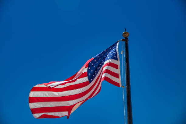 istock Beautiful american flag under a blue sky, USA. 1367817102
