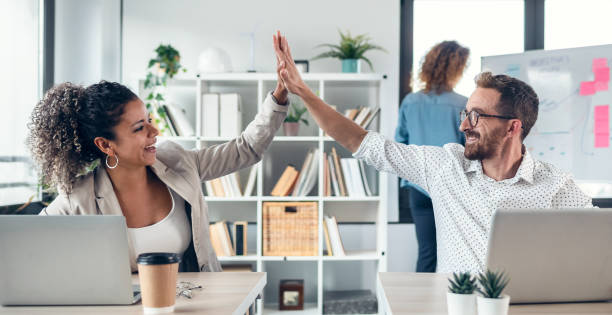 istock Successful business multiage team celebrating standing around table in the coworking space. 1367817991
