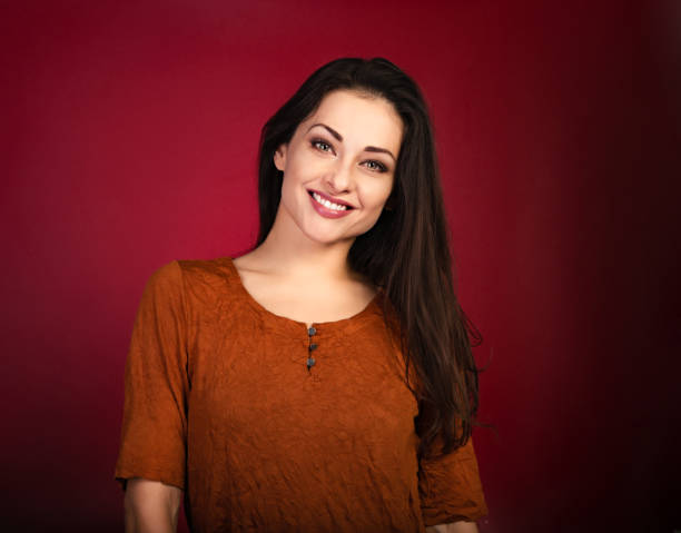 istock Beautiful happy smiling woman on dark red background with empty copy space. Closeup front view portrait of natural female. Valentine's Day 1367818999