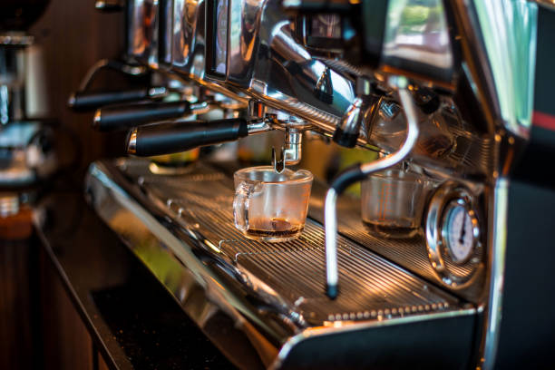 barista preparing fresh espresso on coffee brewing machinery