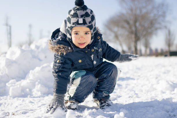 Little boy playing in a snow. He is in a public park. Belgrade, Serbia