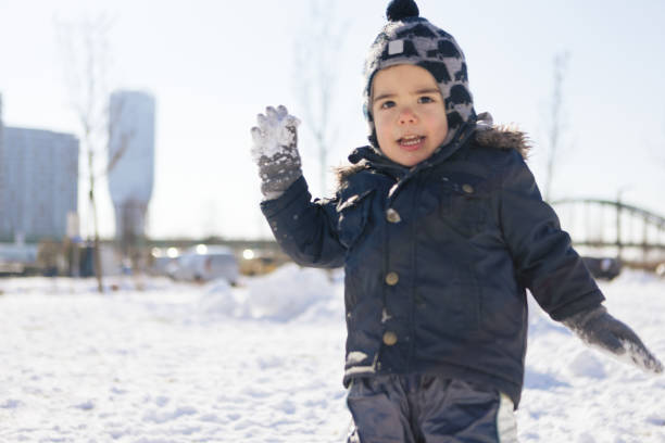 Little boy playing in a snow. He is in a public park. Belgrade, Serbia
