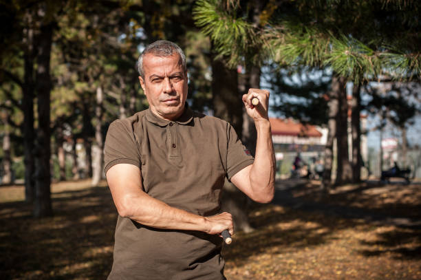 istock Escrima and kapap instructor demonstrates sticks fighting techniques in park 1367824873