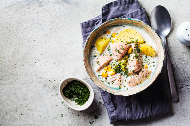 Norwegian fish soup with trout, potatoes and corn, gray background. Norwegian fish soup with trout, potatoes and corn, gray background, top view, copy space. Salmon and potato chowder. Chowder stock pictures, royalty-free photos & images