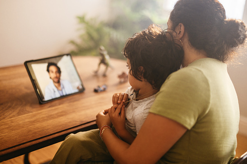 Madre e hijo videollamando a su médico de familia en casa photo