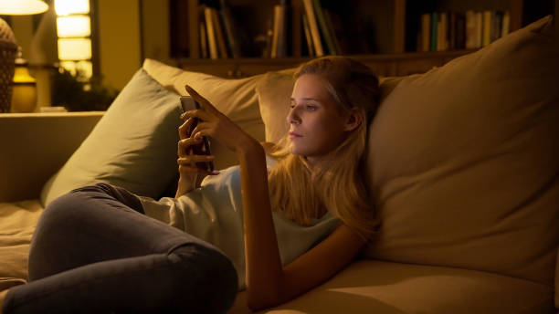istock Beautiful woman bored on a couch. Using  smart phone 1367827905